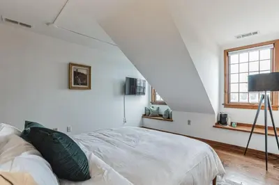 a white bedroom with a bed and a window at Charming Studio in Thornton PA in Thornton