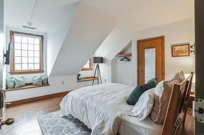 a white bedroom with a bed and a window at Charming Studio in Thornton PA in Thornton