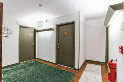 a hallway with two doors and a green rug at Charming Studio in Thornton PA in Thornton