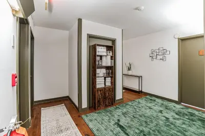 a hallway with a green rug and a book shelf at Historic Thornton Studio Retreat in Thornton