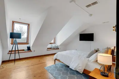 a white bedroom with a bed and a tv at Historic Thornton Studio Retreat in Thornton