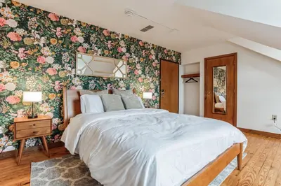 a bedroom with a large bed with floral wallpaper at Historic Thornton Studio Retreat in Thornton