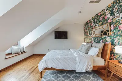 a bedroom with a bed with a floral accent wall at Historic Thornton Studio Retreat in Thornton