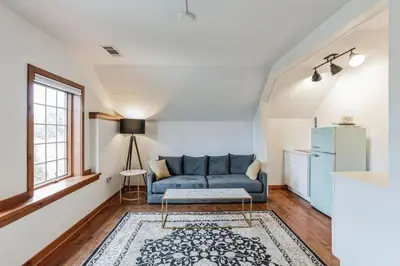 a living room with a blue couch and a refrigerator at Thornton Studio with Kitchenette in Thornton