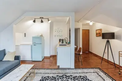 a living room with a blue couch and a kitchen at Thornton Studio with Kitchenette in Thornton