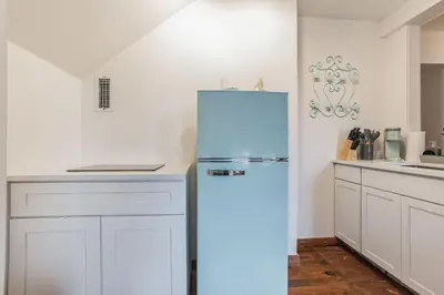 a refrigerator in a kitchen with white cabinets at Thornton Studio with Kitchenette in Thornton
