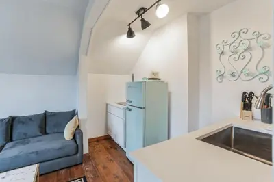 a living room with a blue couch and a refrigerator at Thornton Studio with Kitchenette in Thornton