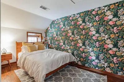 a bedroom with a large floral wall mural at Thornton Studio with Kitchenette in Thornton