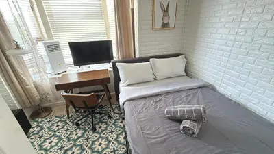 a room with a bed and a desk with a computer at Cozy apartment with city skyline. Easy commute midtown Manhattan. in Jersey City