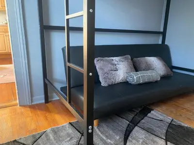 a black bunk bed with two pillows on it at Cozy apartment with city skyline. Easy commute midtown Manhattan. in Jersey City