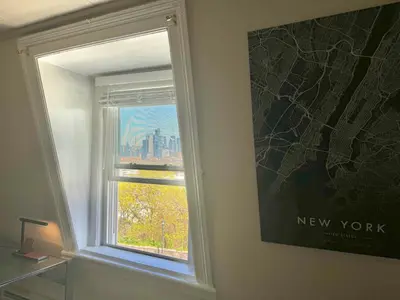 a window with a view of a new york city at Cozy apartment with city skyline. Easy commute midtown Manhattan. in Jersey City