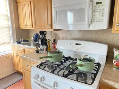 a kitchen with a stove with two pots on it at Cozy apartment with city skyline. Easy commute midtown Manhattan. in Jersey City