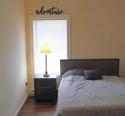 a bedroom with a bed and a lamp and a window at Luxury 6 BR Rebel Ridge Retreat-Sleeps 16-Hot Tub & Linens Included in Albrightsville