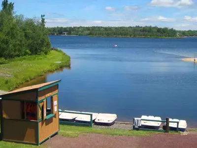 a small house with boats on the shore of a lake at Luxury 6 BR Rebel Ridge Retreat-Sleeps 16-Hot Tub & Linens Included in Albrightsville