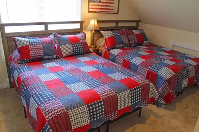 two beds sitting next to each other in a room at Luxury 6 BR Rebel Ridge Retreat-Sleeps 16-Hot Tub & Linens Included in Albrightsville
