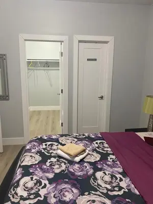 a bedroom with a bed with a purple and white blanket at King Suite 8Mins to Newark Airport in Newark