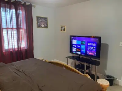 a bedroom with a bed and a television on a stand at King Suite 8Mins to Newark Airport in Newark