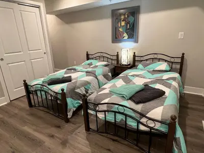 two twin beds in a room with a door at Charming 3BR 2BA with Private Patio in Philadelphia