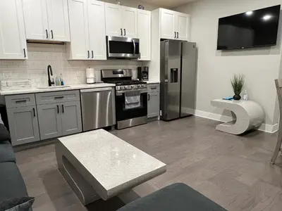 a kitchen with white cabinets and stainless steel appliances at Charming 3BR 2BA with Private Patio in Philadelphia