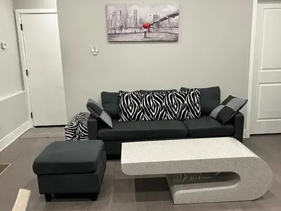 a living room with a black couch and a stool at Charming 3BR 2BA with Private Patio in Philadelphia