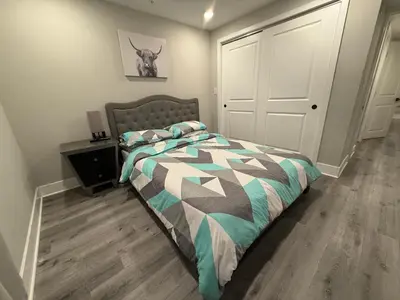 a bedroom with a bed with a comforter and a door at Charming 3BR 2BA with Private Patio in Philadelphia