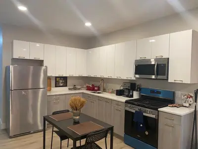 a kitchen with a refrigerator and a table in it at Stylish Room 8Mins to Newark Airport in Newark
