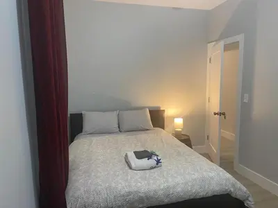 a bed with a white bag on top of it at Stylish Room 8Mins to Newark Airport in Newark