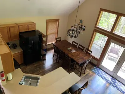 a kitchen and dining room with a table and a refrigerator at Gorgeous House in Camelback Mountain near lifts! in Tannersville