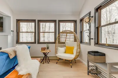 a room with a bed and a chair and windows at Family-Friendly Big Bass Lake Vacation Rental! in Gouldsboro