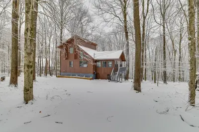 a cabin in the woods in the snow at Family-Friendly Big Bass Lake Vacation Rental! in Gouldsboro