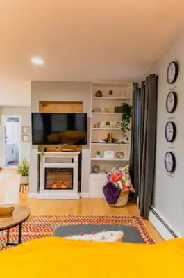 a living room with a television and a fireplace at New Beautiful Apartment In Bayonne near Subway Path Train Manhattan NYC in Bayonne