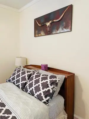 a bed with a wooden headboard and a picture on the wall at Spacious 2-Bedroom Near Elkins Park, Monthly Disco in Elkins Park