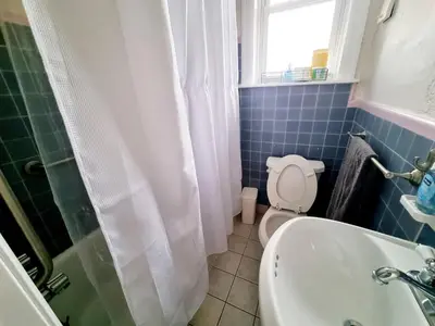 a bathroom with a toilet and a sink and a window at Spacious 2-Bedroom Near Elkins Park, Monthly Disco in Elkins Park