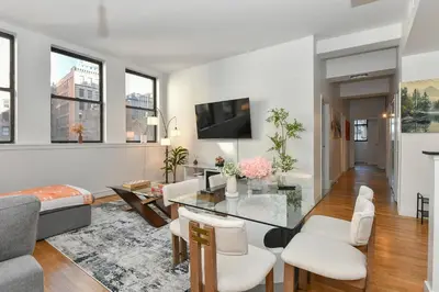 a living room with white furniture and windows at Luxury 3 Bedroom Retreat in Downtown Manhattan in New York