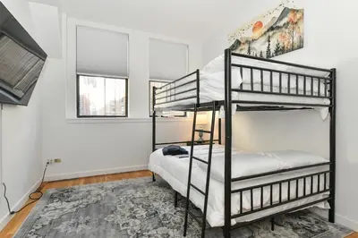 a bedroom with two bunk beds and two windows at Luxury 3 Bedroom Retreat in Downtown Manhattan in New York
