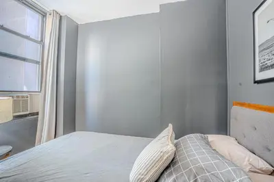 a small bedroom with a bed with a window at Chic 3Bd NoMad Manhattan in New York