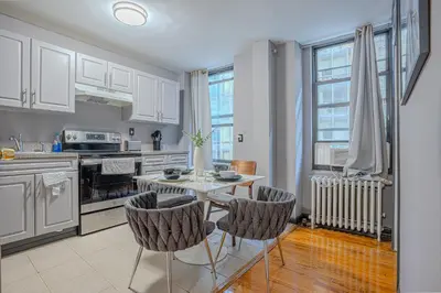 a kitchen with a table and chairs in a room at Chic 3Bd NoMad Manhattan in New York