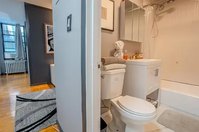 a bathroom with a white toilet and a bath tub at Chic 3Bd NoMad Manhattan in New York