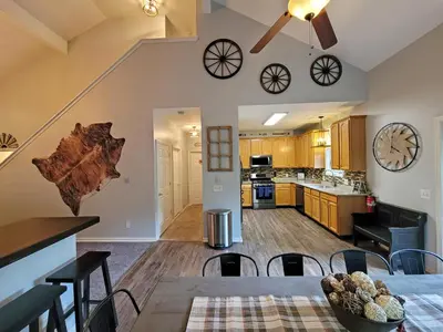 an open living room and kitchen with a dining table and chairs at 5 BR Coyote Cliff Corner HUGE Luxury w/Hot Tub and Linens in Albrightsville