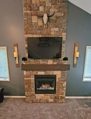 a living room with a stone fireplace with a tv at 5 BR Coyote Cliff Corner HUGE Luxury w/Hot Tub and Linens in Albrightsville