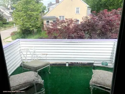 a balcony with two chairs and a pool of green water at Bryn Mawr Guest Suites in Bryn Mawr