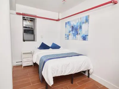 a bedroom with a bed with blue pillows at Comfy Guest House in Hell's Kitchen in New York
