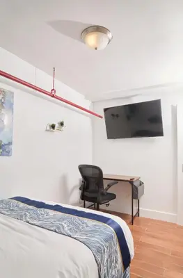 a bedroom with a bed and a desk and a chair at Comfy Guest House in Hell's Kitchen in New York