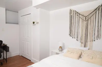 a white bedroom with a bed and a window at Comfy Guest House in Hell's Kitchen in New York