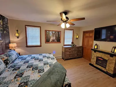 a bedroom with a bed and a ceiling fan at Red Rock Run - Luxury 6 BR Secluded Home with Hot Tub & Linens in Albrightsville