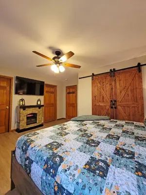a bedroom with a bed and a ceiling fan at Red Rock Run - Luxury 6 BR Secluded Home with Hot Tub & Linens in Albrightsville