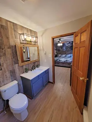 a bathroom with a white toilet and a sink at Red Rock Run - Luxury 6 BR Secluded Home with Hot Tub & Linens in Albrightsville