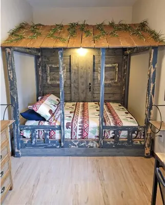 a bed with a wooden frame in a room at Red Rock Run - Luxury 6 BR Secluded Home with Hot Tub & Linens in Albrightsville