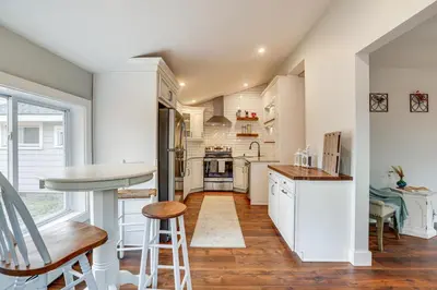 a kitchen with white cabinets and a table at In-Town and Walkable Historic Yardley Retreat! in Yardley