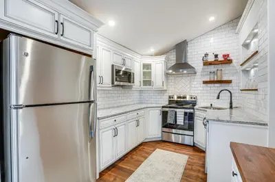 a kitchen with white cabinets and a stainless steel refrigerator at In-Town and Walkable Historic Yardley Retreat! in Yardley